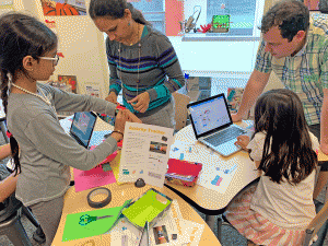 Family members and students design activity trackers using Scratch programming and micro:bit controllers.